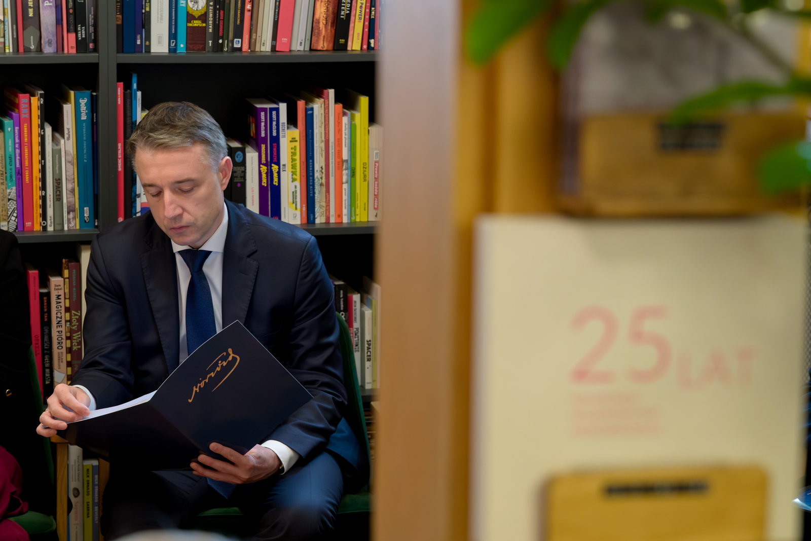 Przewodniczący siedzi i czyta.
